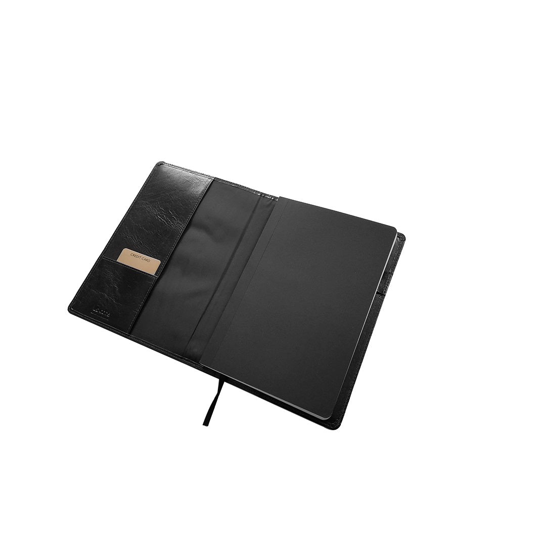 A black leather notebook cover shown open against a plain white background, featuring a small beige leather nameplate on the left side.